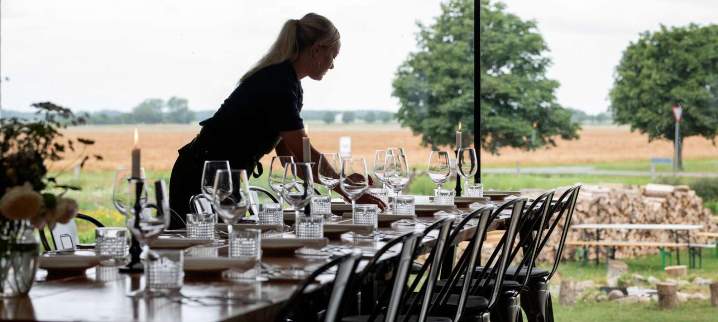 Tjener dækker bord på restaurant