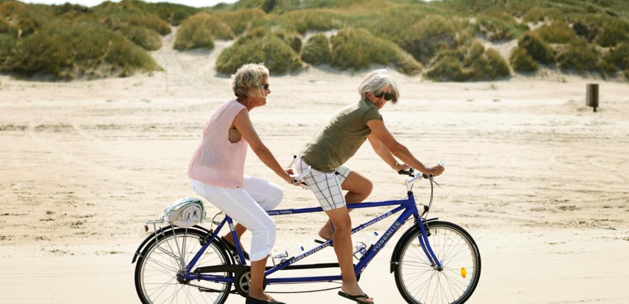 Veninder cykler tandem på strand