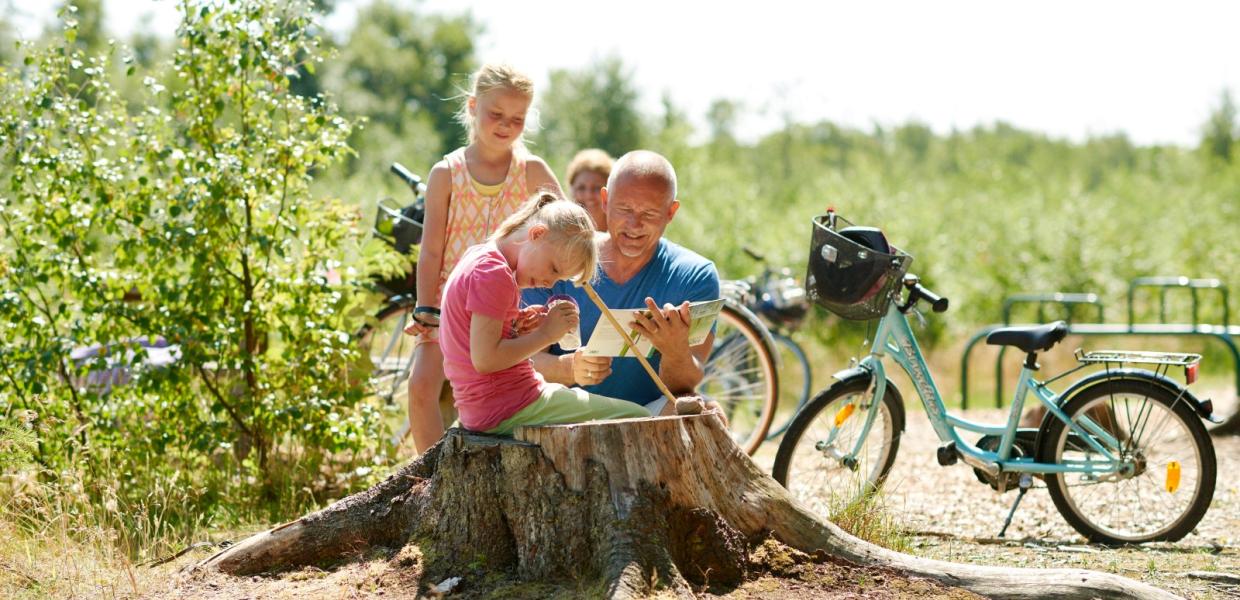 Familie i naturen med cykel