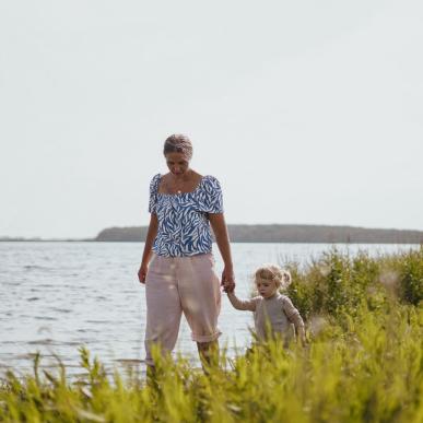 Mor og datter går ved kysten