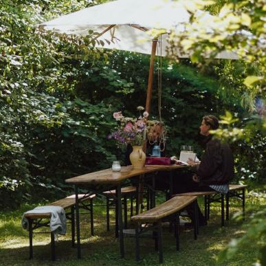 Mand sidder ved havebord på Ro Naturcamp
