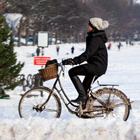 Kvinde på cykel om vinteren