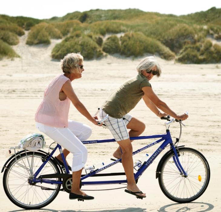 Veninder cykler tandem på strand